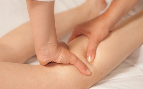 der Masseur knetet sein Bein